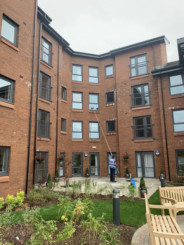 Cleaning windows on a block of flats for a commercial client using Reach & Wash.
